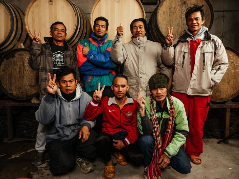 Thai Vineyard Crew poses in the barrel room